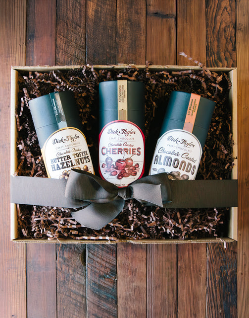 Gift box displaying 1 tube of Chocolate Coated Butter Toffee Hazelnuts, Chocolate Coated Cherries, and Chocolate Coated Almonds.