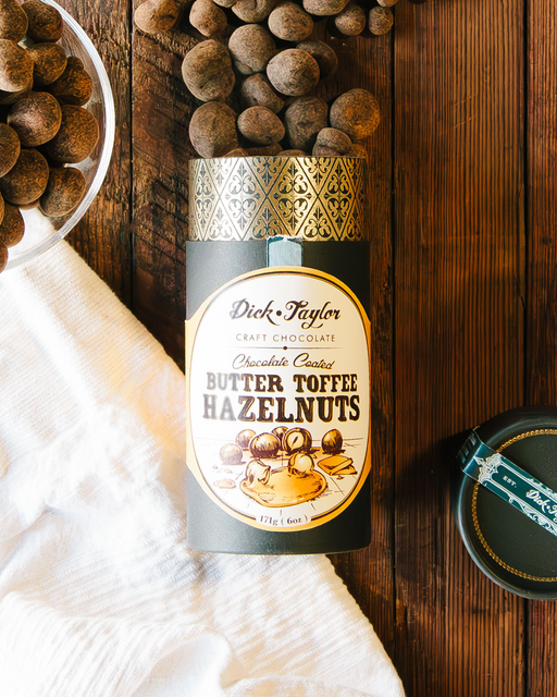 Tube of Chocolate Coated Butter Toffee Hazelnuts opened with hazelnuts spilling out. 