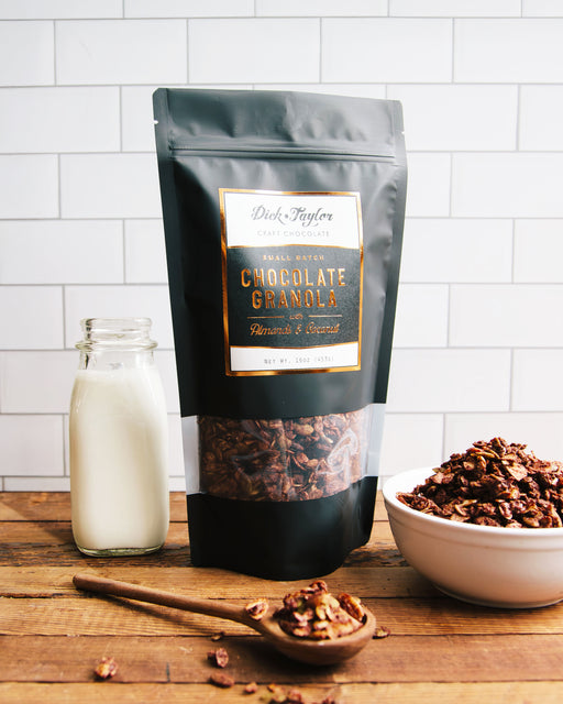Bag of Chocolate Granola feature with a bowl of chocolate granola and a small jar of milk.